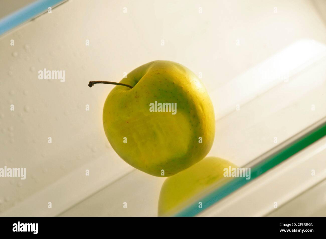 Gebissen grünen Apfel in einem ansonsten leeren Kühlschrank, Diät Stockfoto