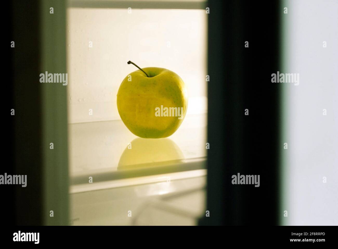 Gebissen grünen Apfel in einem ansonsten leeren Kühlschrank, Diät Stockfoto