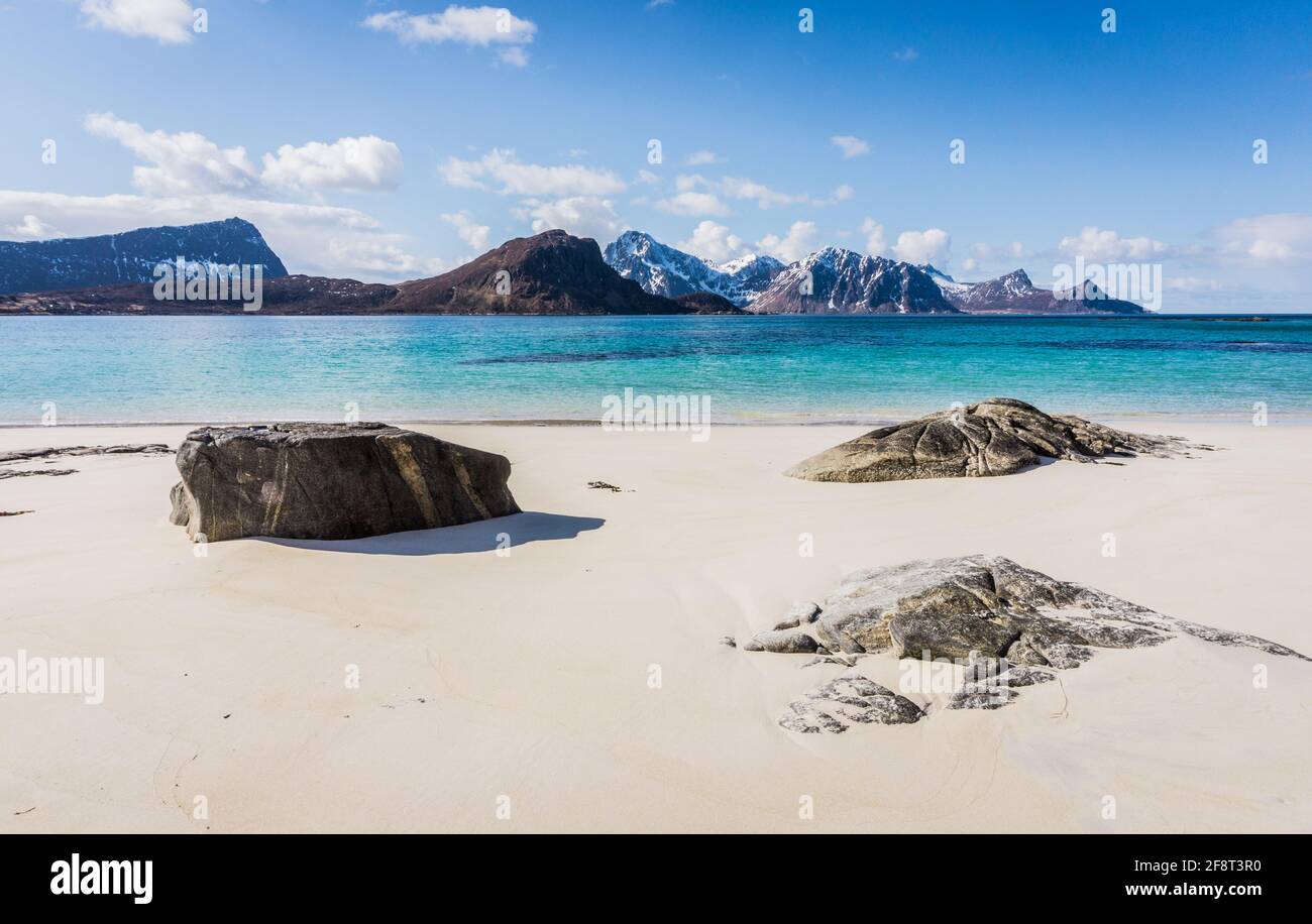 Haukland Beach oder Hauklandstranda, Vestvavoy, Lofoten Islands, Norwegen. Schöner Sandstrand mit Felsen, Blick auf die Berge und blauem Wasser. Keine Personen. Stockfoto