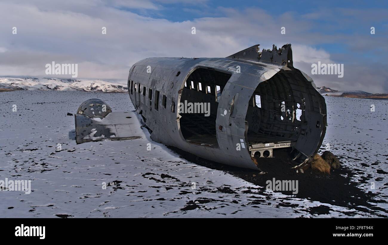 Berühmtes Flugzeugwrack eines DC-3 (C-117)-Flugzeugs am Strand von Solheimasandur an der Südküste im Winter mit spärlicher, schneebedeckter Landschaft. Stockfoto