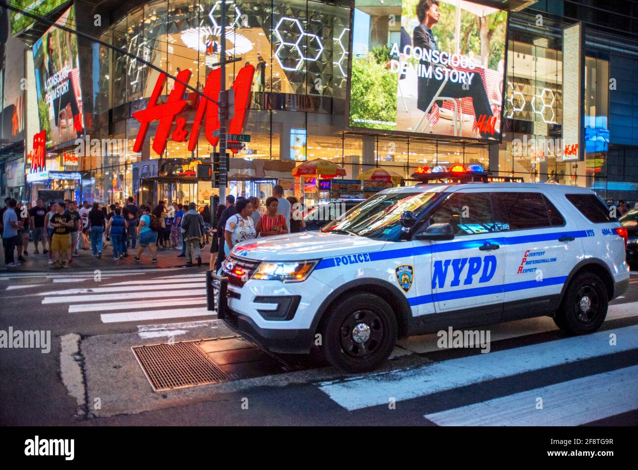 Polizeiauto vor dem H&M-Geschäft in der Nacht, Times Square, New York City, Vereinigte Staaten von Amerika. NYPD-Streifenwagen am Times Square. Manhattan Stockfoto