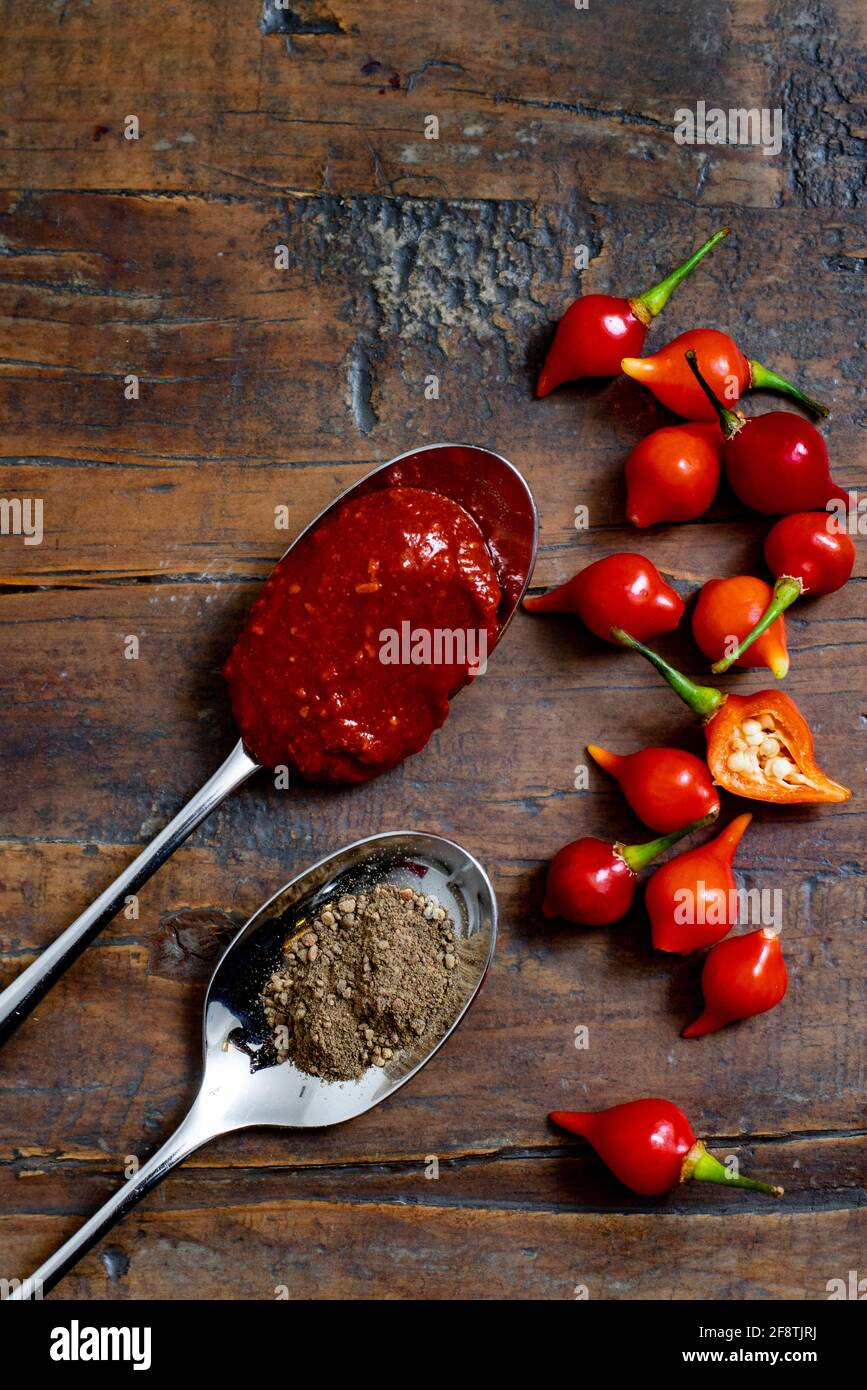 Würzige Zutaten und Gewürze aus Chilisauce auf rustikalem Holztisch Vertikal mit Kopierbereich oben Stockfoto