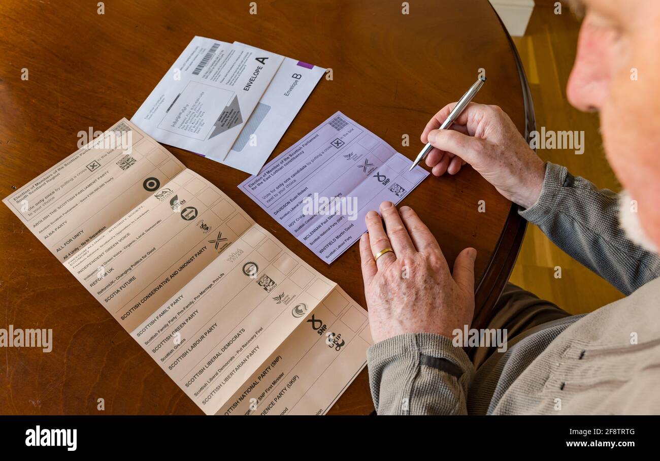 East Lothian, Schottland, Großbritannien, 15. April 2021. Für die schottischen Wahlen kommen Briefwahlen an: Die Bewohner des Bezirks können ihre Stimmen für die MSP East Lothian und die Region South of Scotland abgeben. Kandidaten für die ehemalige Partei sind Euan Davidson (Scottish Liberal Democrats), Craig Hoy (Scottish Conservative & Unionists), Paul McLennan (SNP) & Martin Whitfield (Scottish Labour & ehemaliger Abgeordneter, der 2019 an Kenny MacAskill, der für Alba steht, verloren hat). Die Regionalliste umfasst 16 Parteien. Ein Mann überlegt, für wen er auf dem Stimmzettel stimmen soll Stockfoto