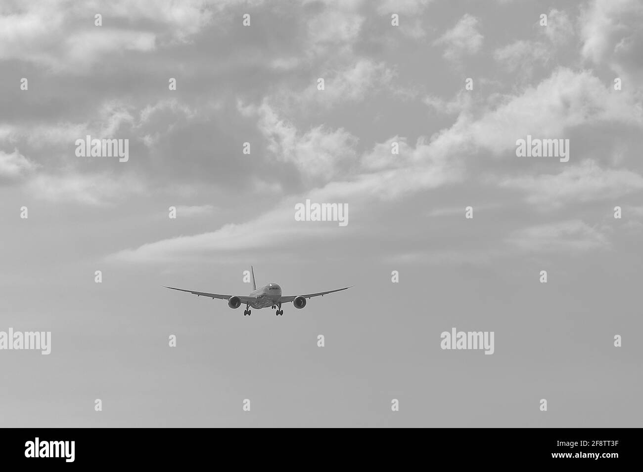 Ein Flugzeug, das in den Himmel mit Wolke in monochromen fliegen Stockfoto