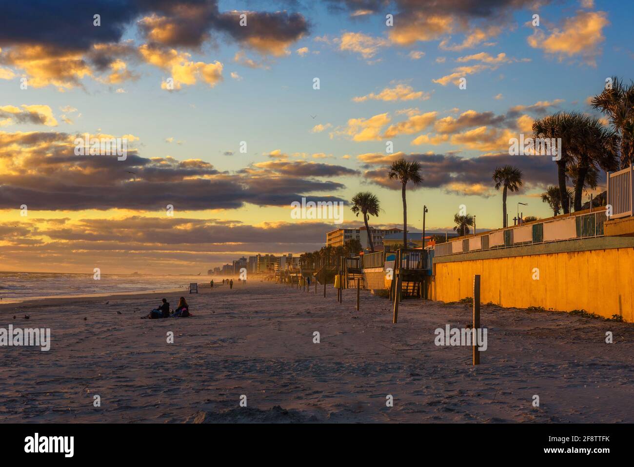 Küste von Dayona Beach in Florida bei Sonnenaufgang mit Menschen Und Palmen Stockfoto