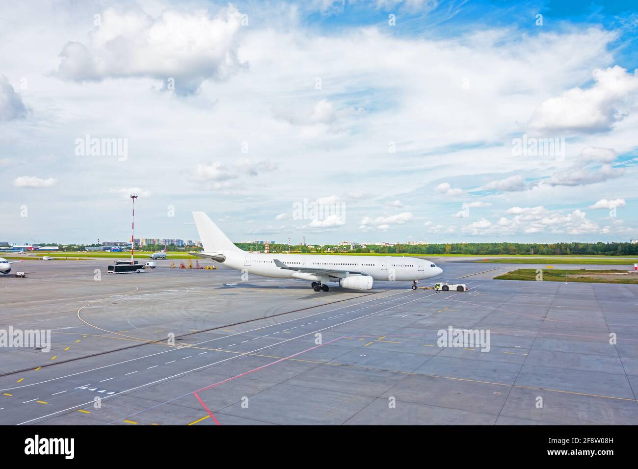 Schieben Sie das Flugzeug zuvor mit einem Abschleppwagen zurück Starten der Motoren und Abheben vom Flughafen Stockfoto