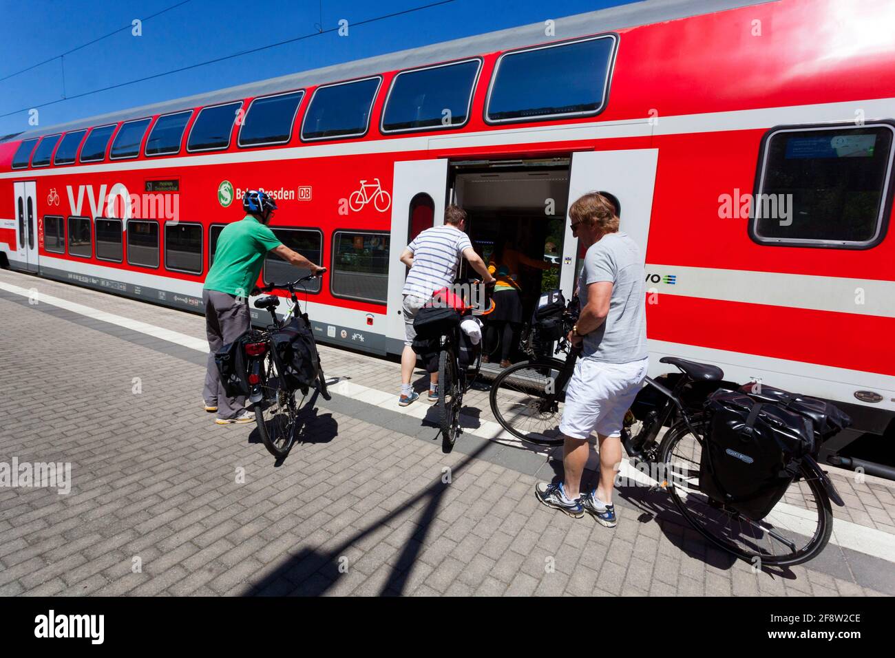 Eine Gruppe von drei Radfahrern, die in einen Zug steigen, Bahnhof Sachsen-Deutschland Stockfoto
