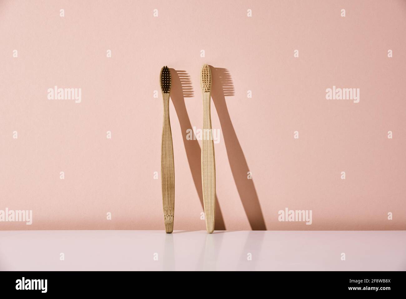 Zwei umweltfreundliche Bambus-Zahnbürsten auf rosa Hintergrund Stockfoto