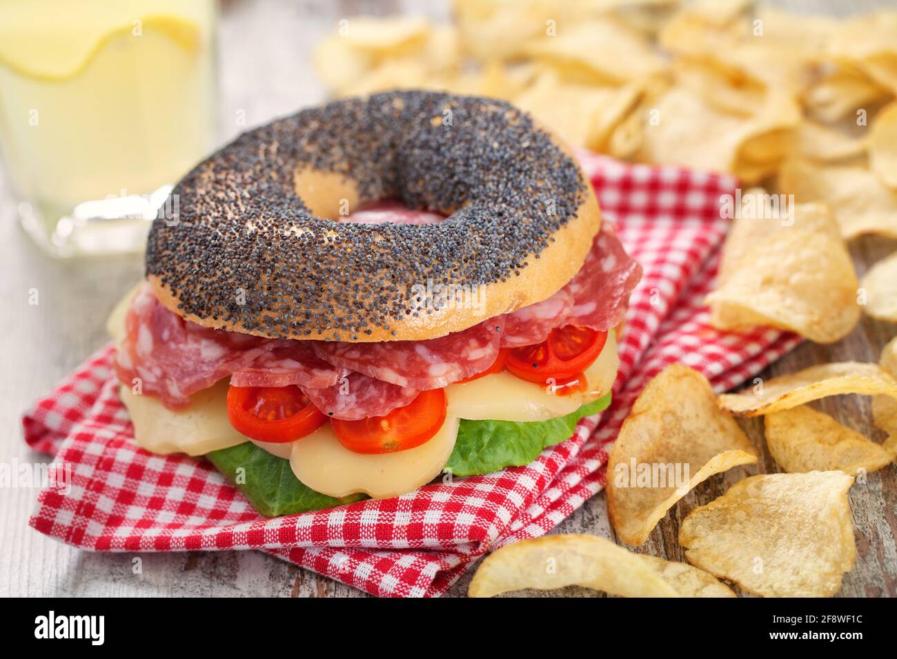 Bagel mit Salami, Käse, Tomaten und frischem Salat. Stockfoto