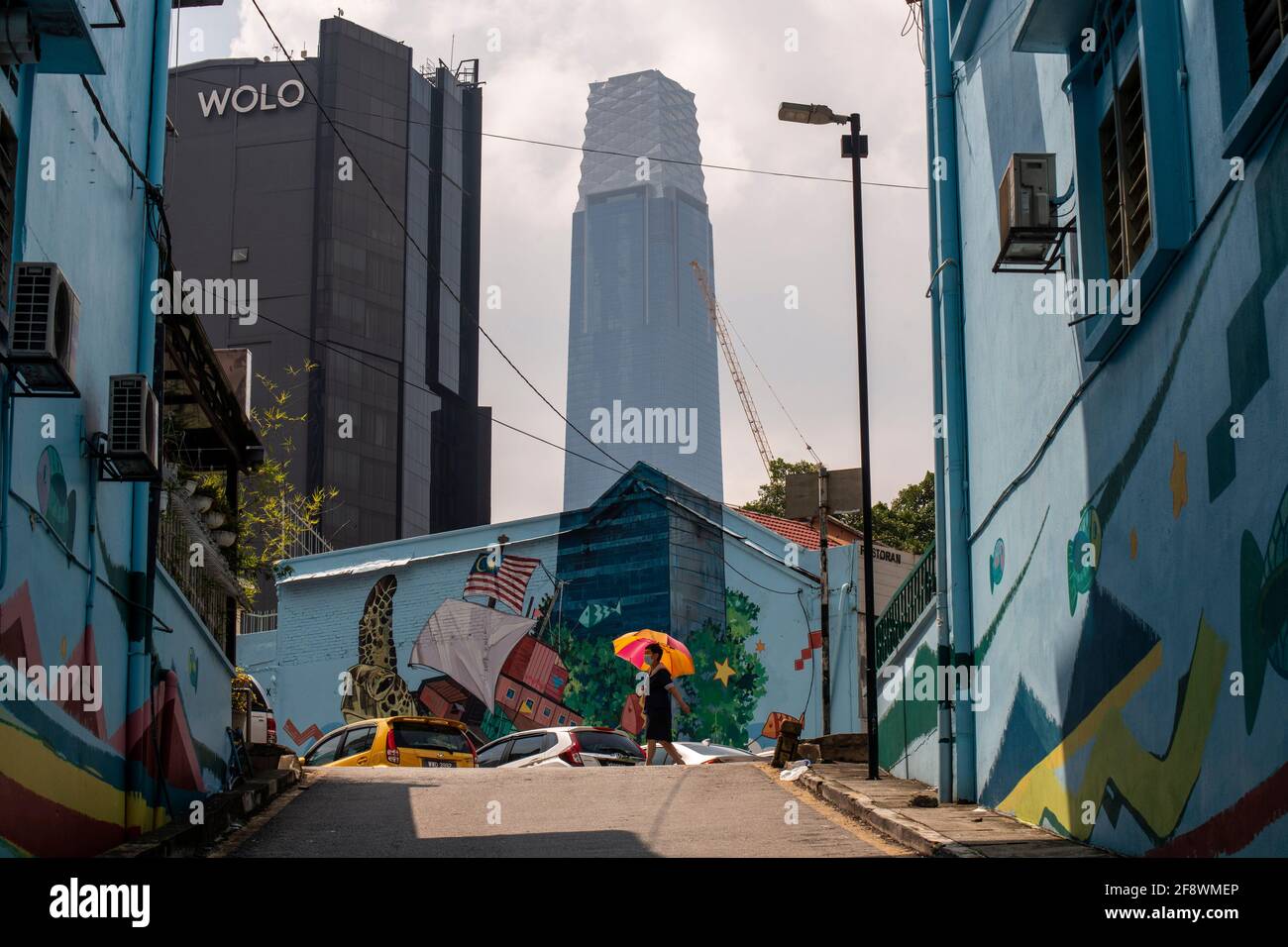 Kuala Lumpur, Malaysia. April 2021. Ein Fußgänger geht in der Nähe eines Wandbildes, das nahtlos mit dem Exchange 106-Turm im Hintergrund in Kuala Lumpur, Malaysia, 15. April 2021, verschmolzen ist. Quelle: Chong Voon Chung/Xinhua/Alamy Live News Stockfoto