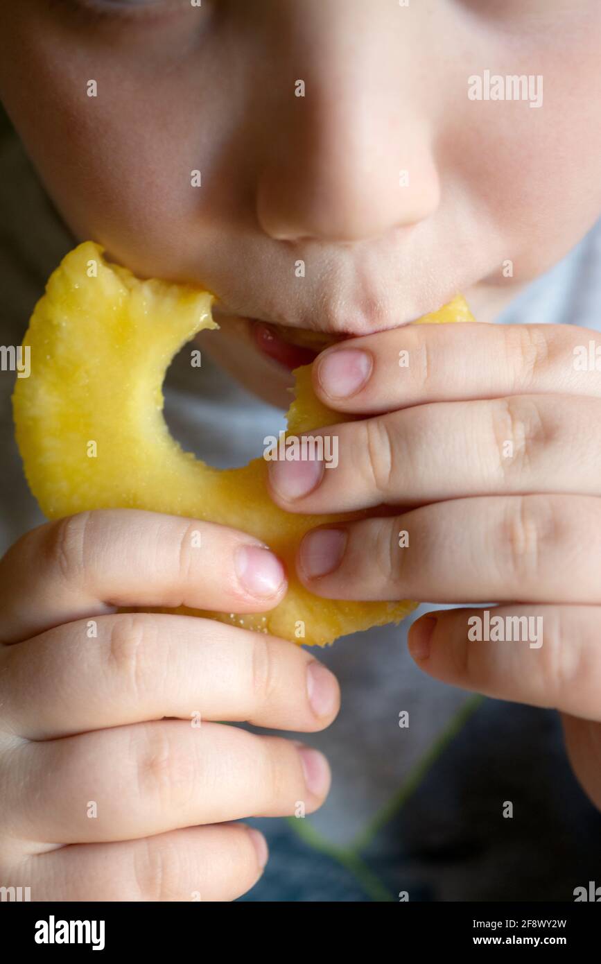 Lttle Boy, der Ananas isst Stockfoto