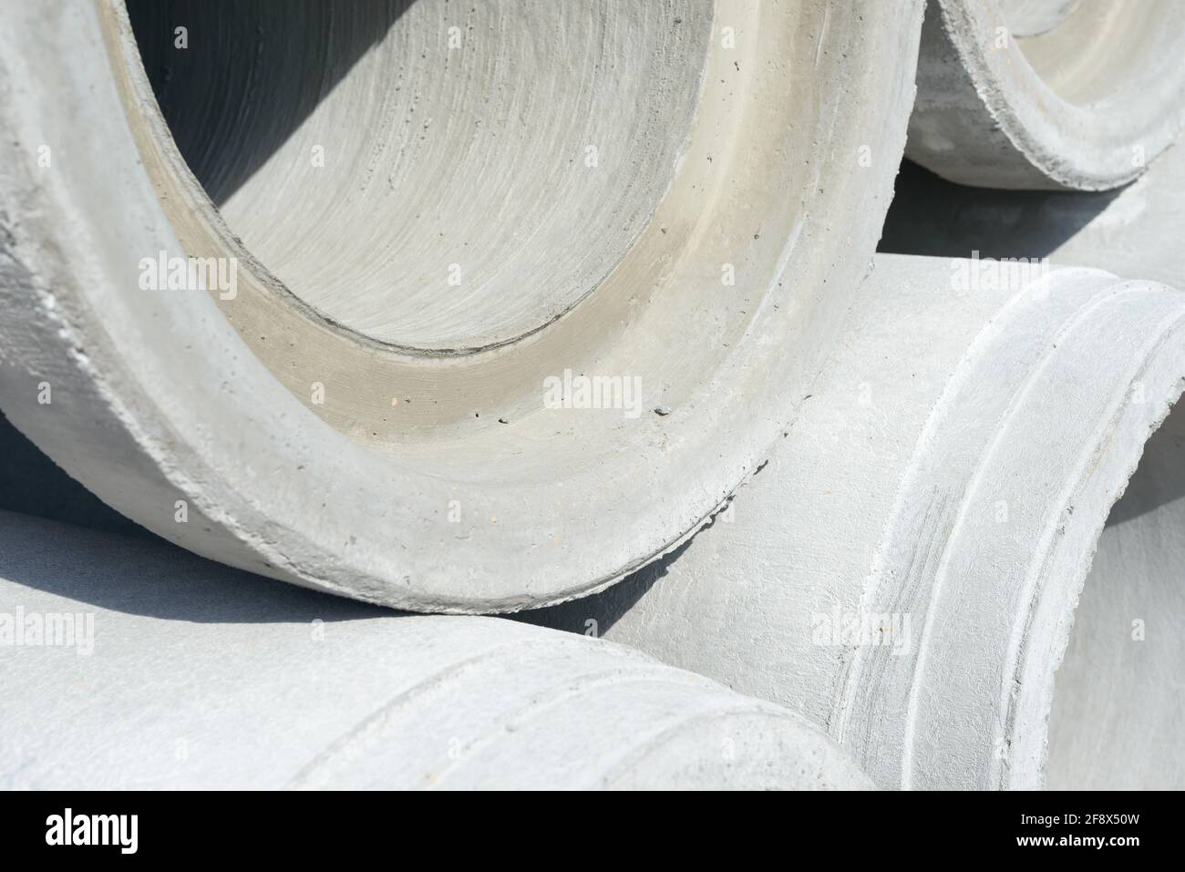 Industriebetonentwässerungsrohre für den Bau gestapelt. Neue Röhrchen. Stockfoto