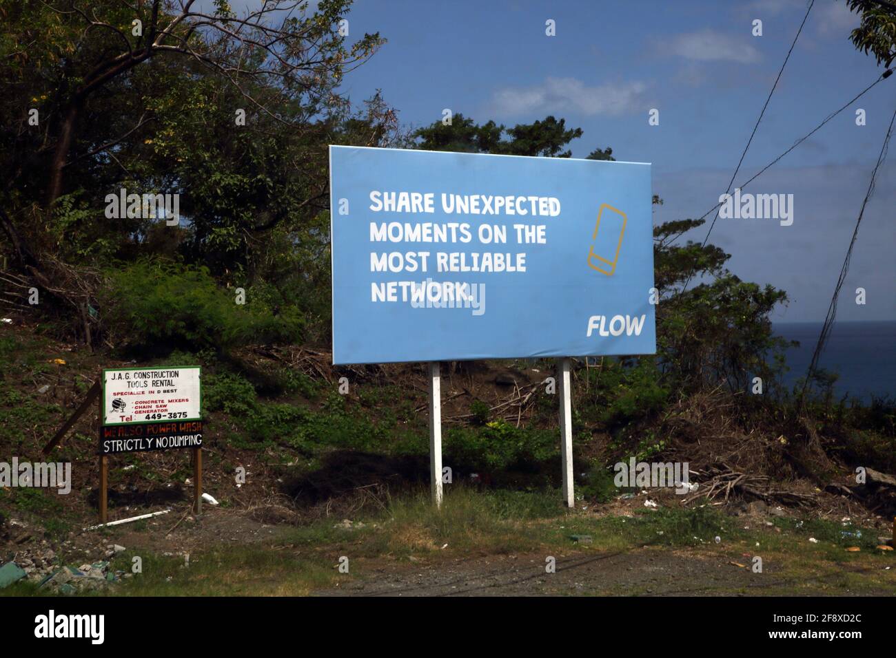 Happy Hill Grenada Werbetafeln auf Coastal Road Advertising Flow Mobile Netzwerk- und Bauunternehmen Stockfoto