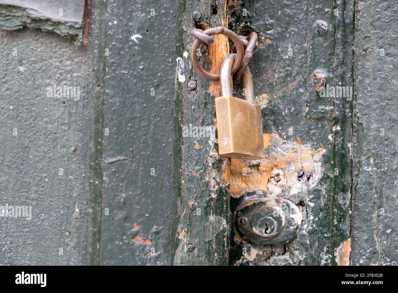 Vorhängeschloss auf schwarzer Holztür in Nahaufnahme, geschlossener gesicherter Hauseingang. Traditionelles Türdetail, Plaka Athens Griechenland Stockfoto