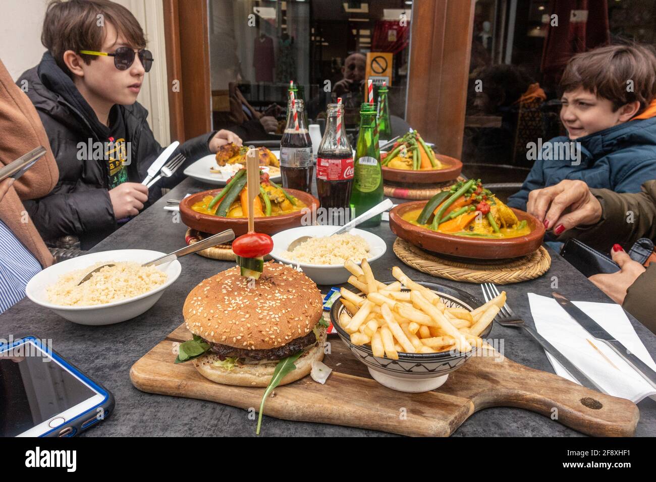 Eine Familie genießt einen gemeinen in einem Restaurant zum ersten Mal seit der Sperre gekauft wegen Coronavirus. Essen im Freien nach den aktuellen Regeln. Stockfoto
