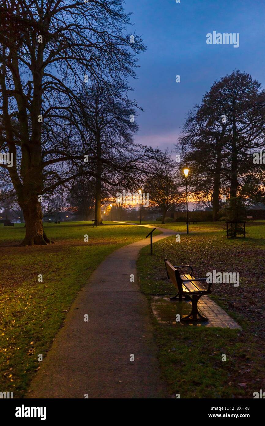 Blick in die Dämmerung auf den Wanderweg durch Abbey Park im Winter, Pershore, Worcestershire, England Stockfoto