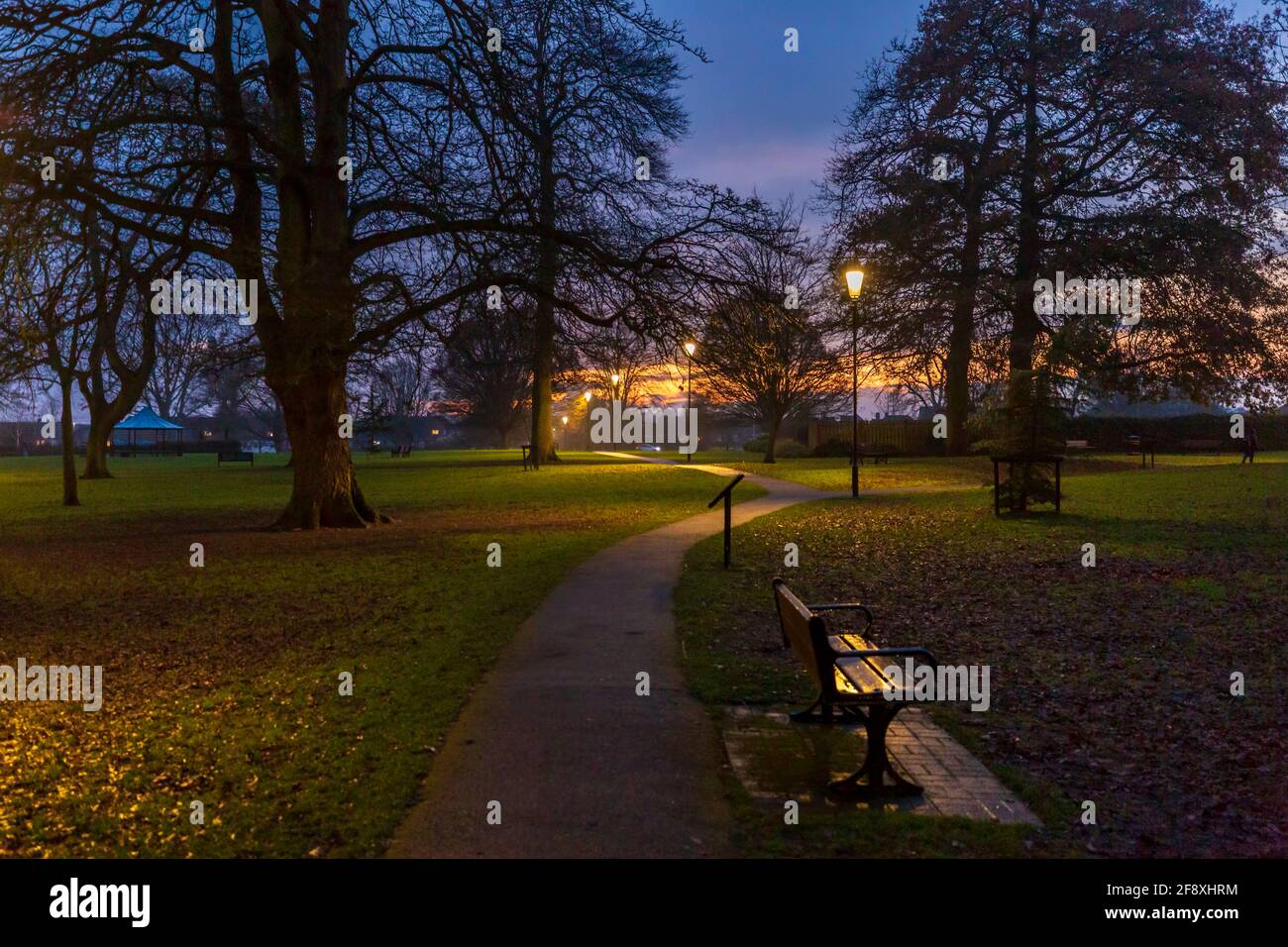 Blick in die Dämmerung auf den Wanderweg durch Abbey Park im Winter, Pershore, Worcestershire, England Stockfoto