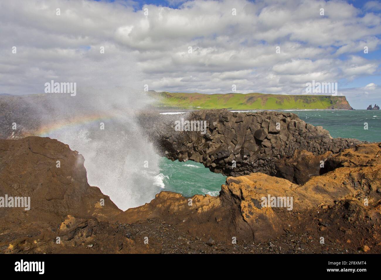 Die Welle stürzte unter natürlichen Bögen, erodierte schwarze Basaltgesteinsformation am Kap Dyrhólaey / Kap Portland in der Nähe von Vík í Mýrdal, Island Stockfoto