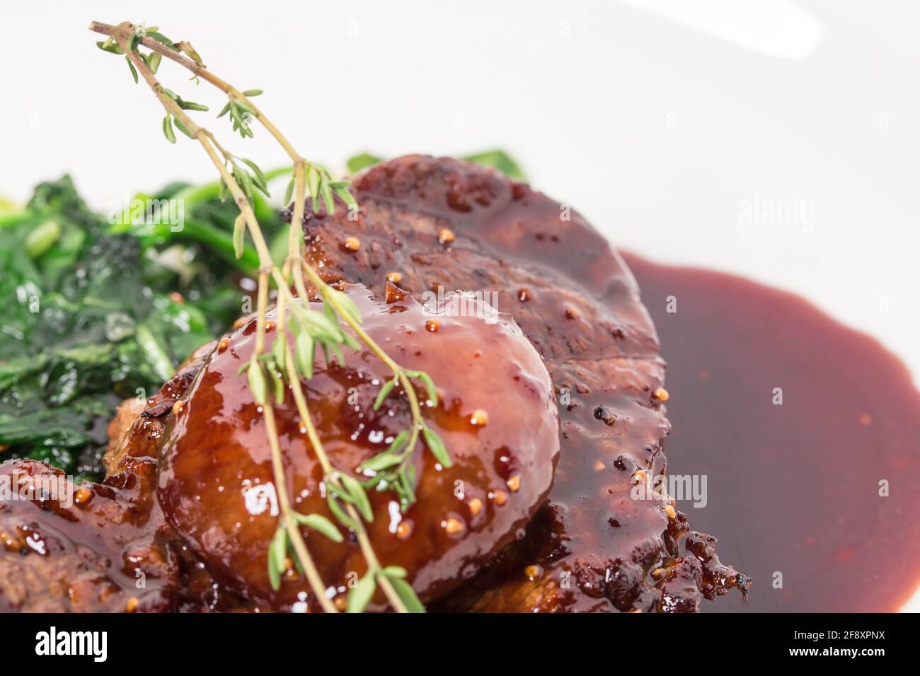 Köstliches gegrilltes Filet-Mignon-Steak mit Mangold, überzogen mit Rotweinsoße. Makro. Selektiver Fokus auf das Steak. Foto kann als ganzer Backgr verwendet werden Stockfoto