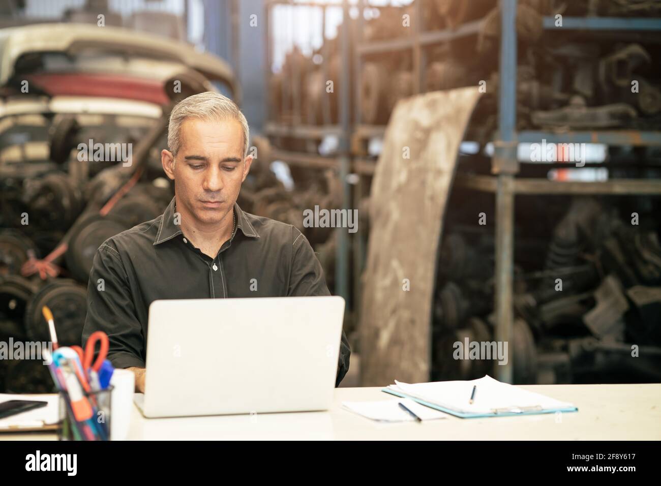 Fabrikbesitzer Manager oder Ingenieur Leiter seriöse Arbeit Am Schreibtisch am Lagerarbeitsplatz Stockfoto