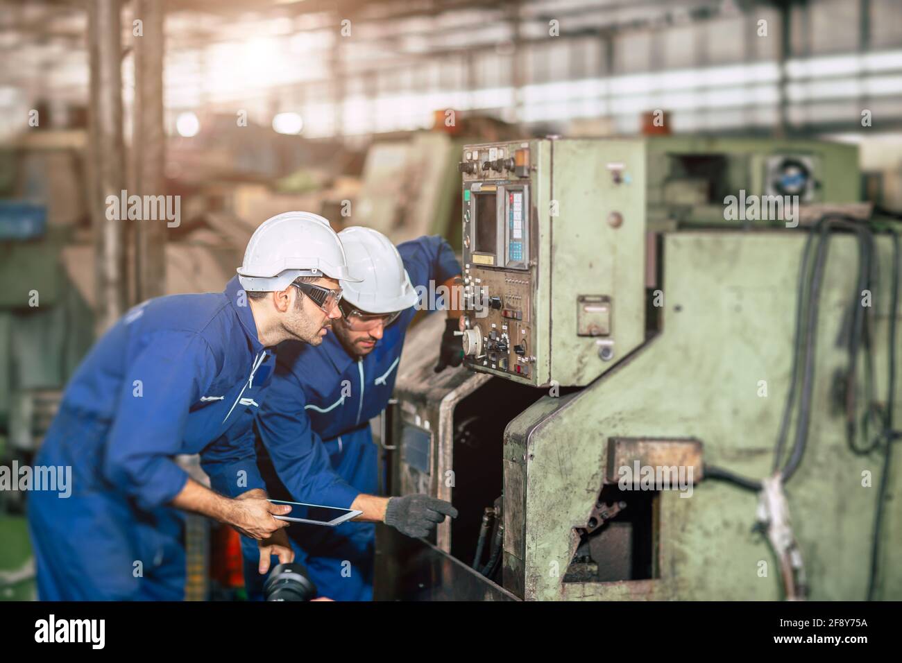 Techniker überprüft den Wartungsservice der Maschine und arbeitet gemeinsam mit dem Team In Stahl schweren Fabrik Stockfoto