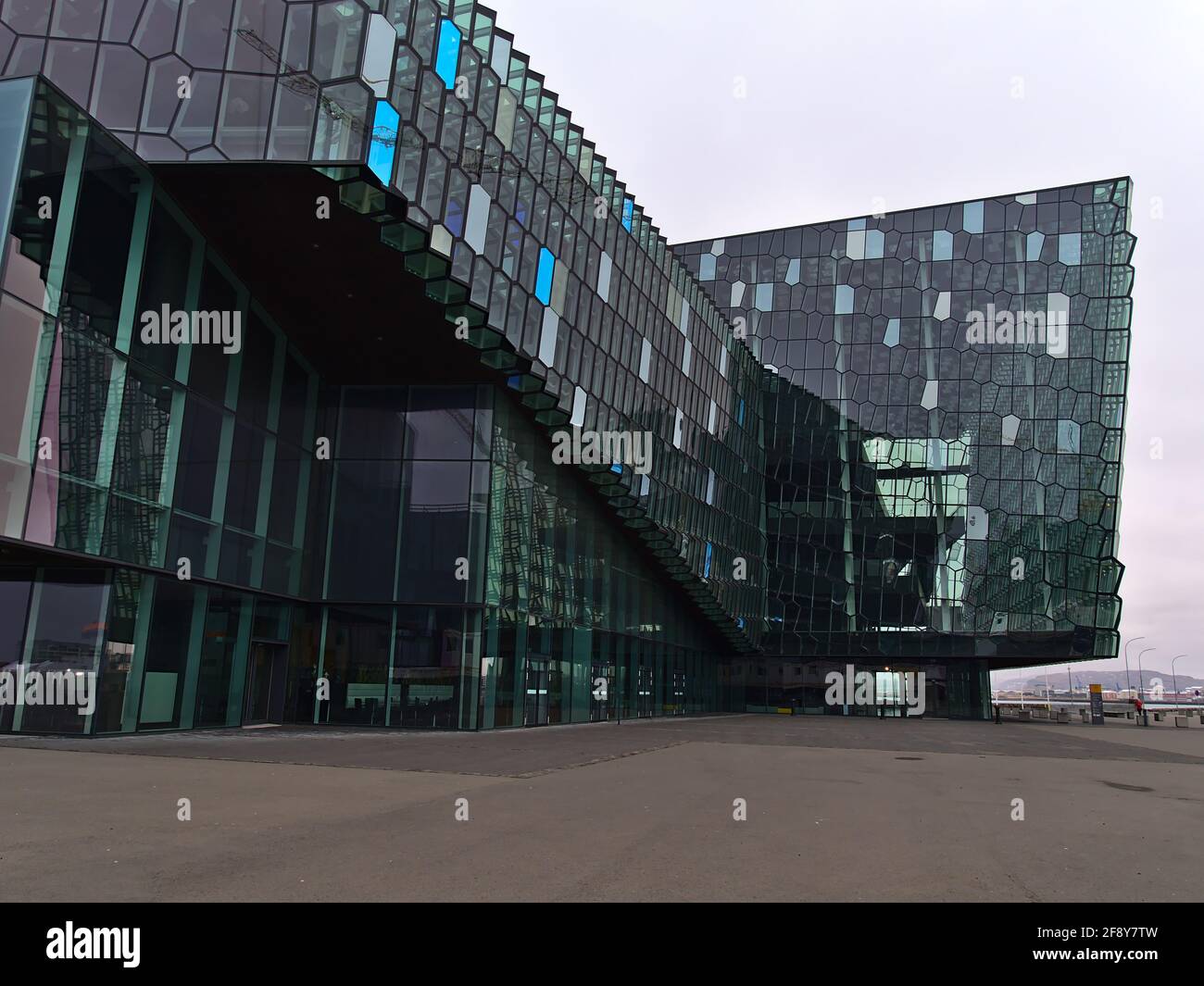 Blick auf die beliebte Konzerthalle und das Konferenzzentrum Harpa im Stadtzentrum von Reykjavik mit einer bunt gemusterten Glasfassade, die von basaltischen Felsen inspiriert ist. Stockfoto