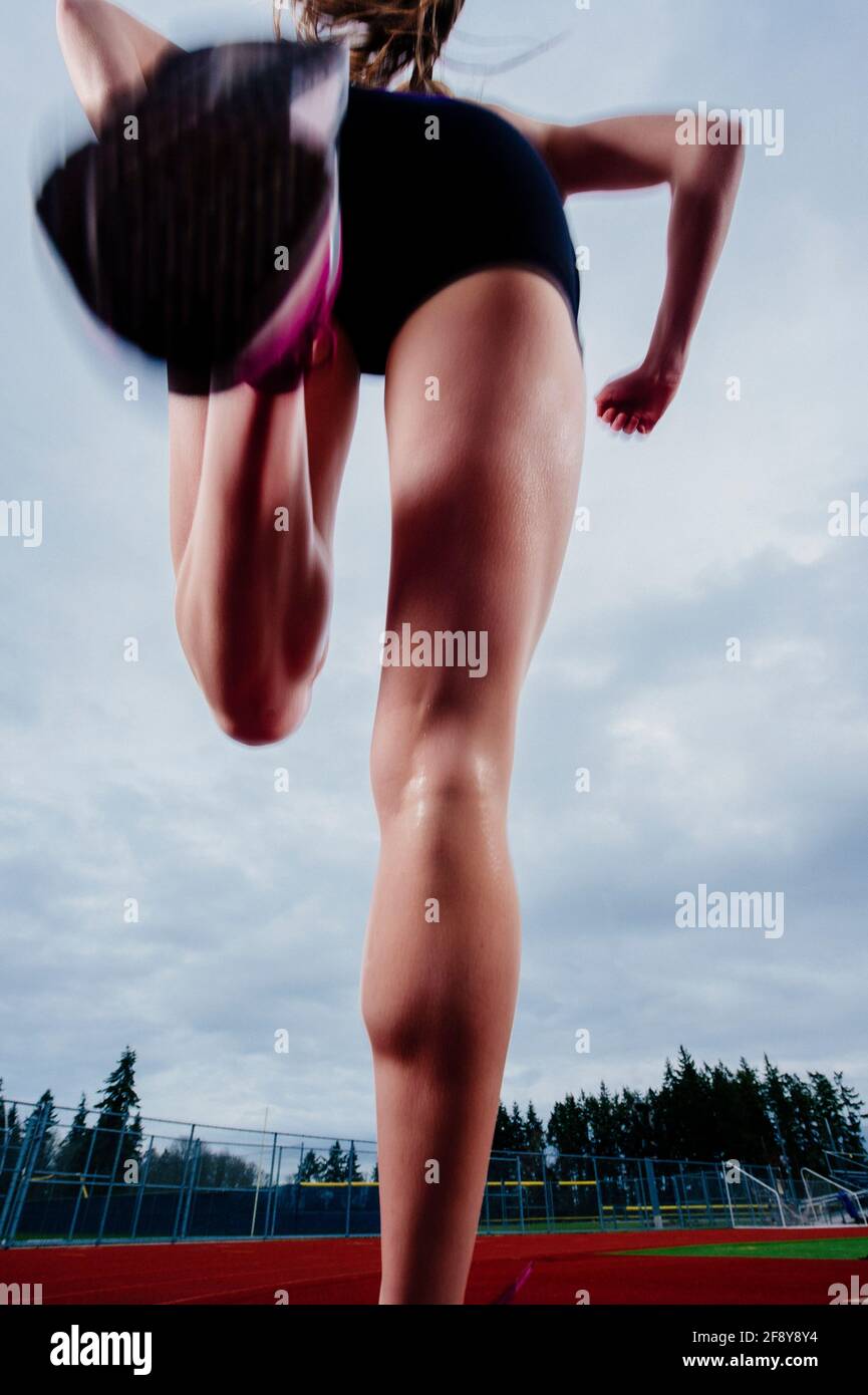 Niedriger Abschnitt der Frau, die auf der Strecke läuft Stockfoto