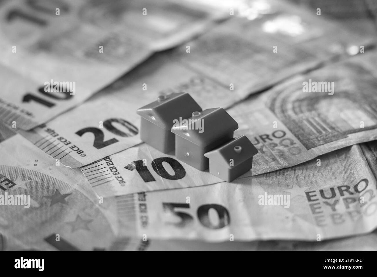 Tisch mit Euro-Banknoten bedeckt mit Häusern auf der Oberseite. Immobilieninvestitionskonzept Stockfoto