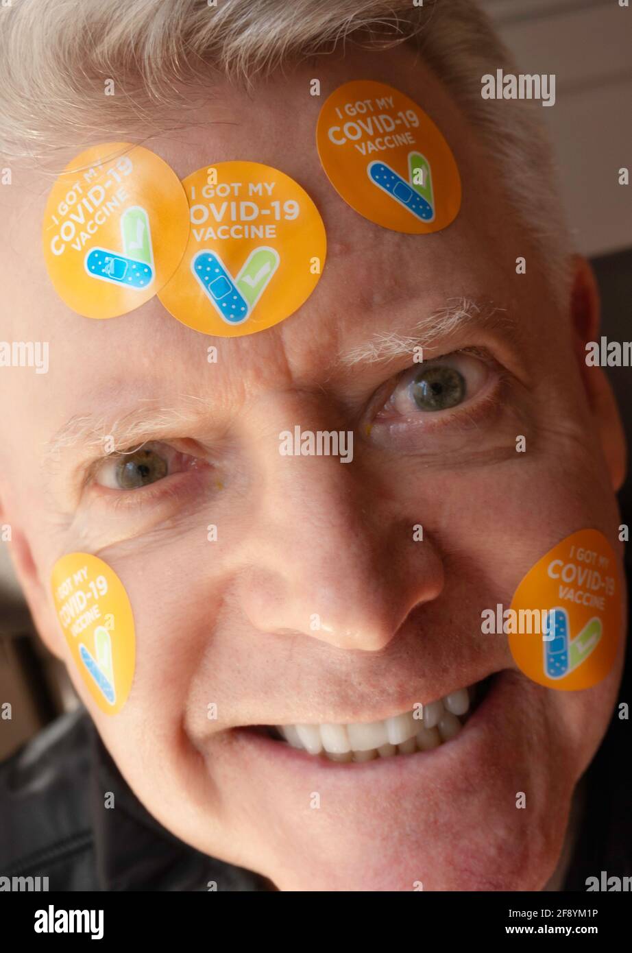 Ein älterer Mann mit dem Aufkleber „Ich habe meinen COVID-19-Impfstoff“ auf seiner Stirn, USA Stockfoto