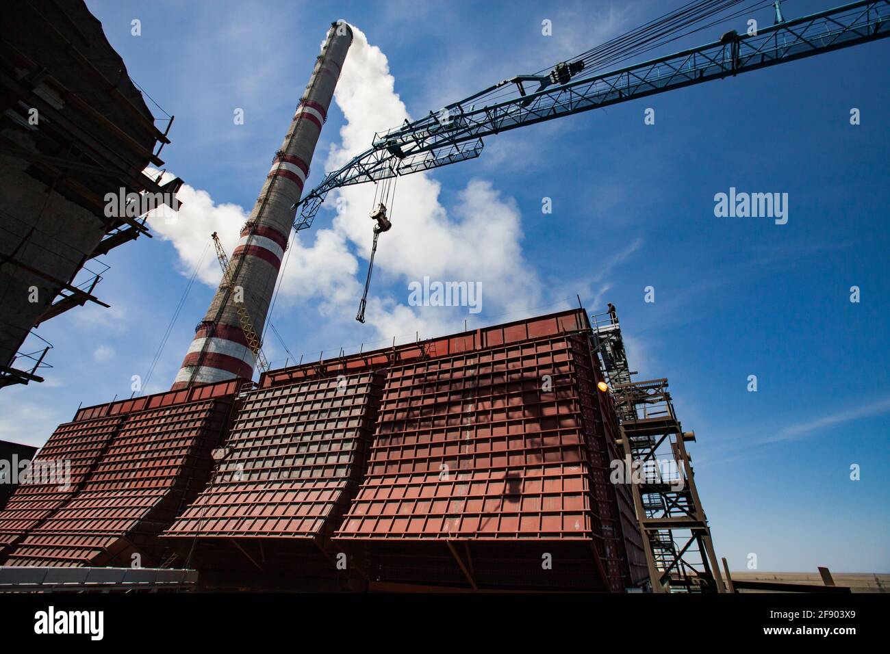 GRES-1 Wärmekraftwerk Modernisierung.Neue riesige Roh-Kohle-Bunker und blauen Bau Kran Jib.Rauch Stapel auf blauen Himmel. Ekibastuz, Kasachstan. Stockfoto
