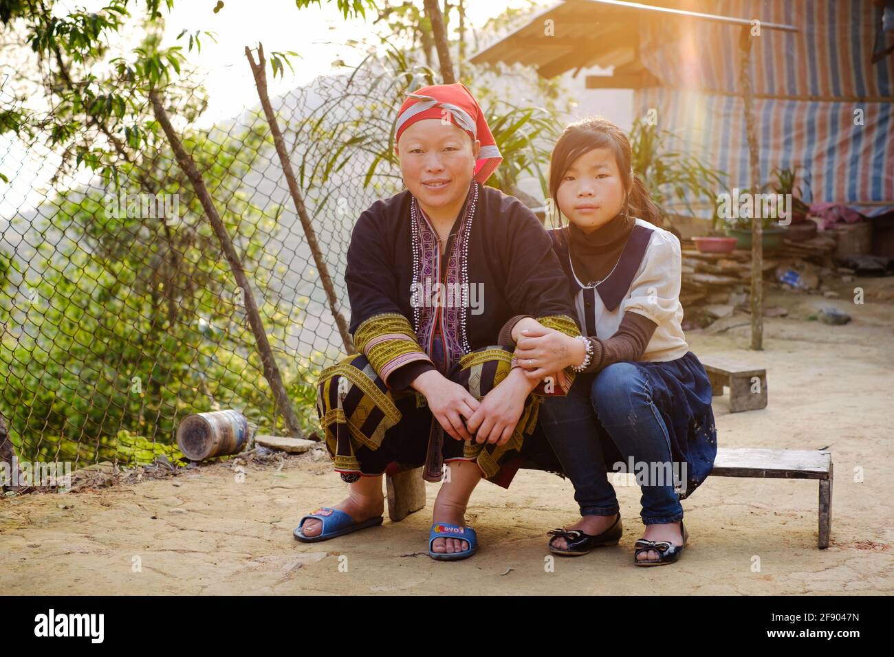 Sapa, Vietnam - April 15: Portrait der ethnischen Minderheit der Roten Dzao in traditioneller Kleidung. Frau und Tochter in der Nähe des Hauses. Stockfoto