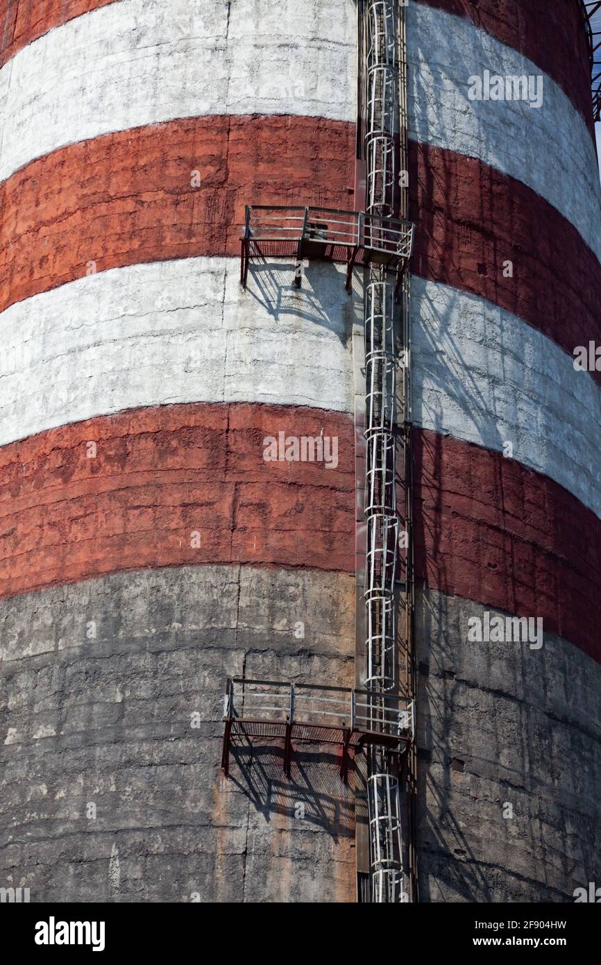 Ekibastuz, Kasachstan. WÄRMEKRAFTWERK GRES-1. Nahaufnahme des Rauchstapels aus Beton. Rot-weiße Streifen, Metalltreppe. Stockfoto