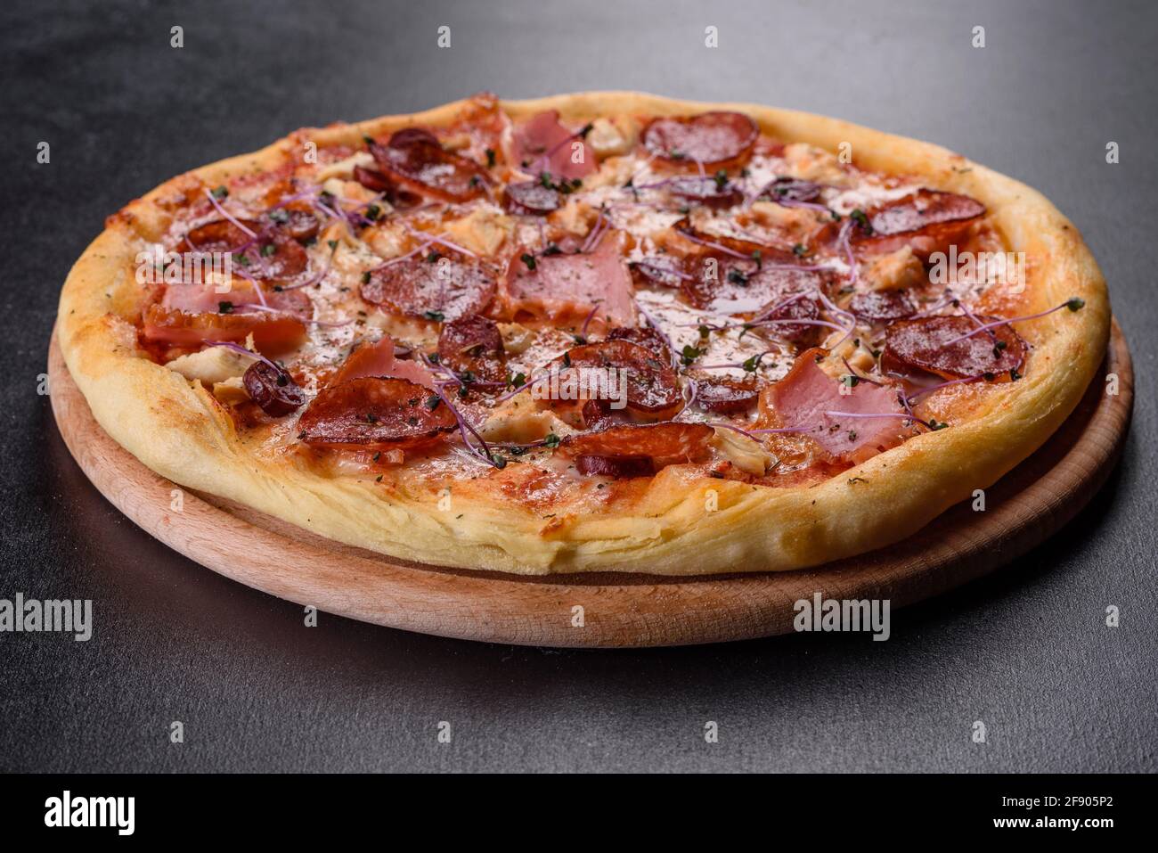 Köstliche frische Ofenpizza mit Tomaten, Salami und Speck auf dunklem  Betonboden. Italienische Küche Stockfotografie - Alamy