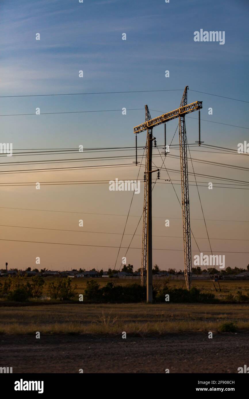 Hochspannungsleitung und elektrischer Turm am schönen Abendhimmel. Stockfoto