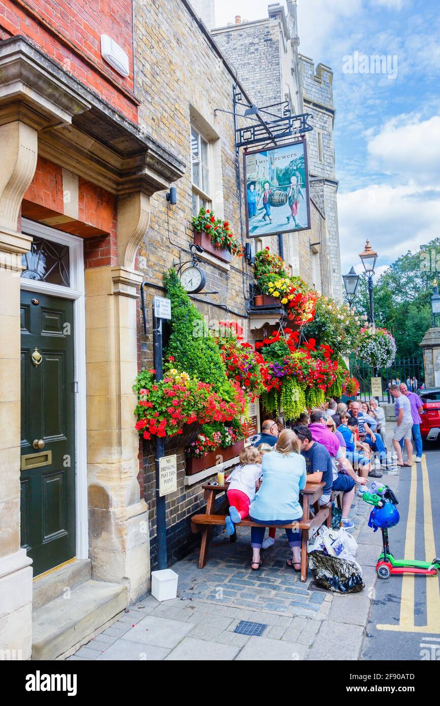 Der Two Brewers Pub im Stadtzentrum von Windsor, in der südöstlichen Grafschaft von England, wo Gäste an einem sonnigen Tag draußen am Straßenrand trinken Stockfoto