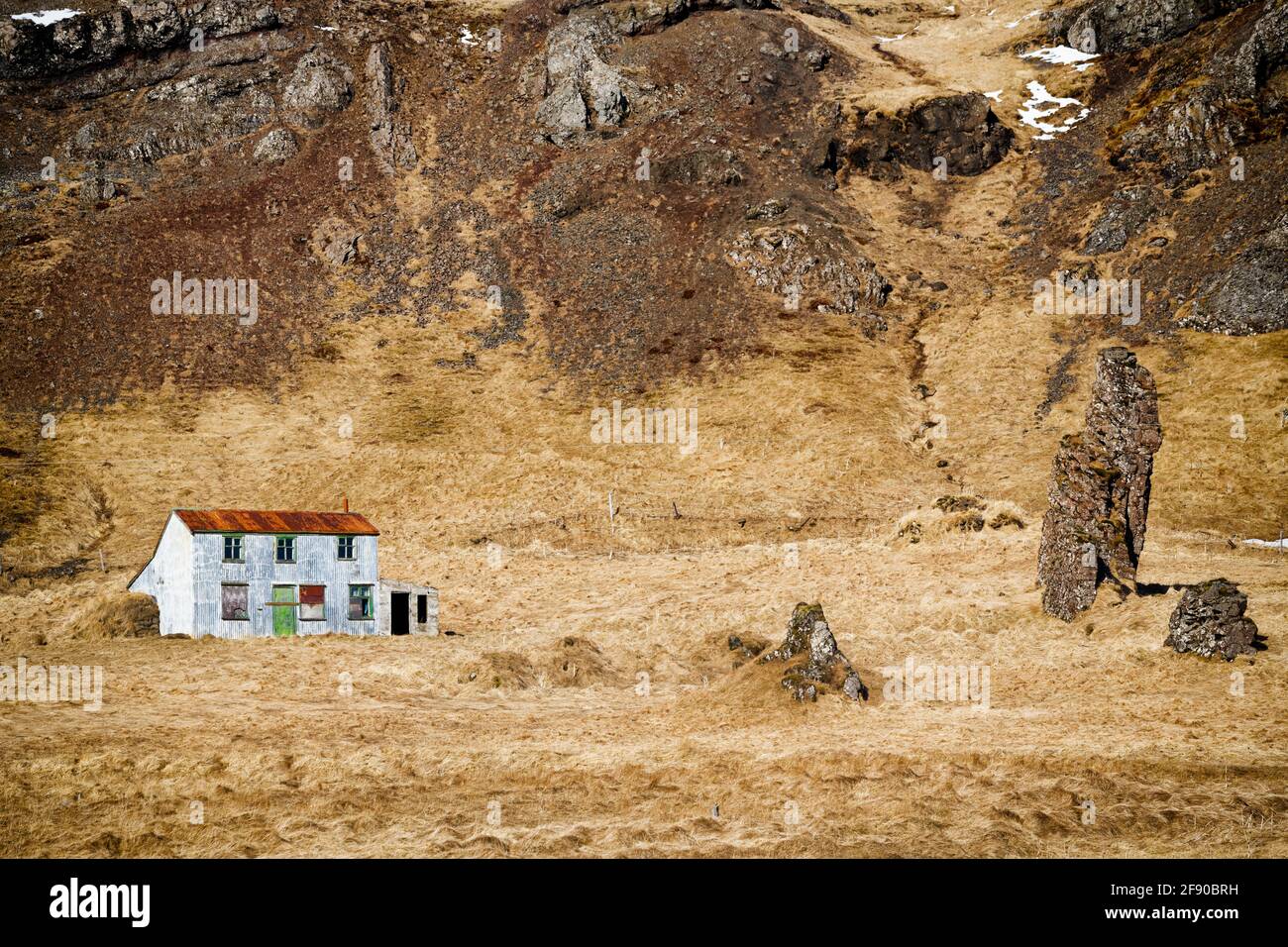 Verlassenes Haus und brauner Berghang, Island Stockfoto