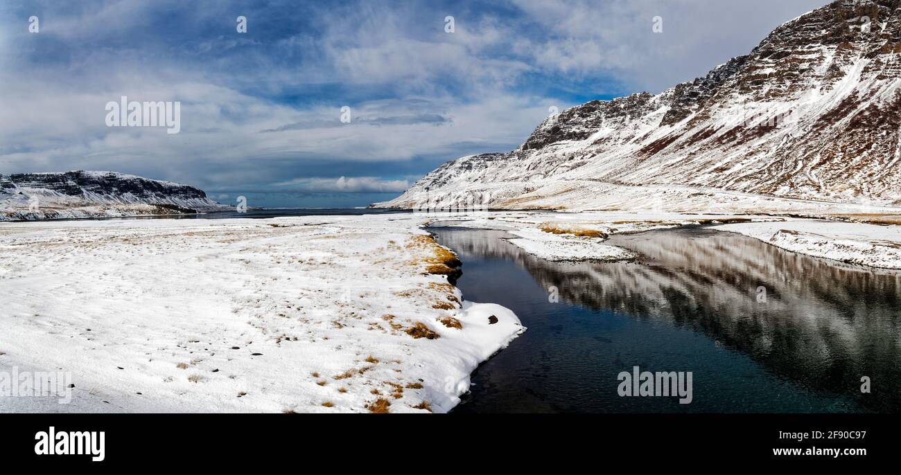 Hügel, die sich im Winter im Wasser spiegeln, Island Stockfoto