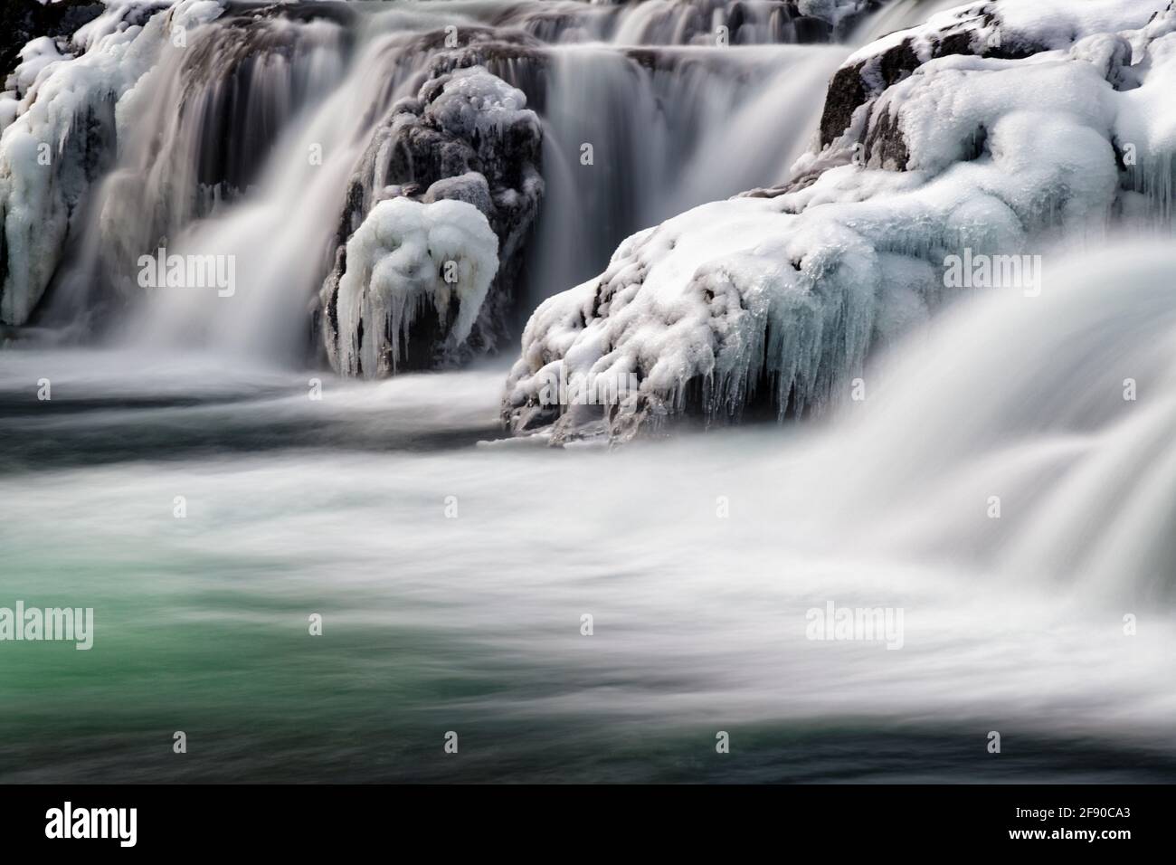 Langzeitaufnahme der Landschaft mit gefrorenem Wasserfall, Island Stockfoto