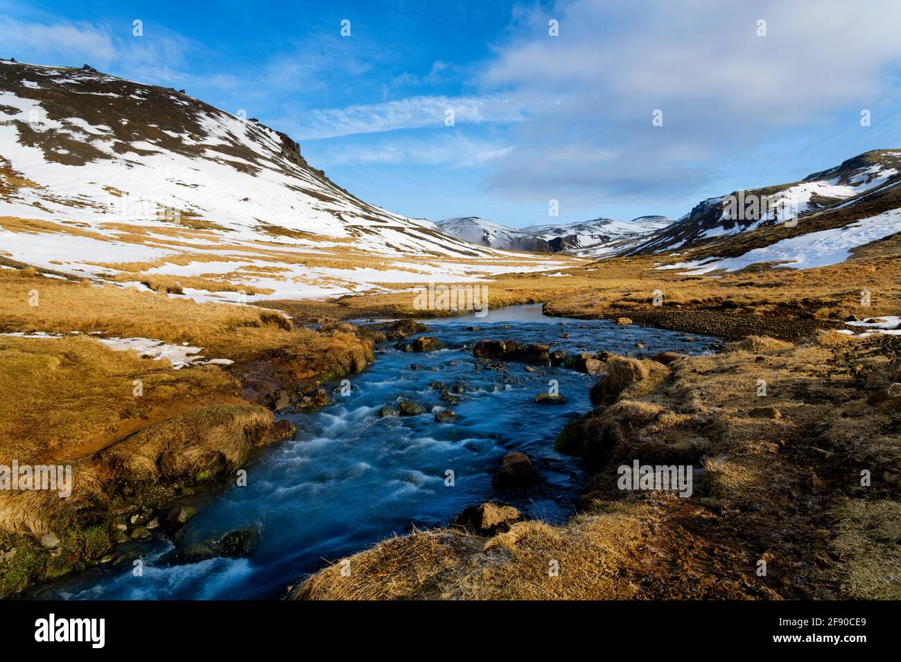 Landschaft mit Fluss und schneebedeckten Hügeln, Island Stockfoto