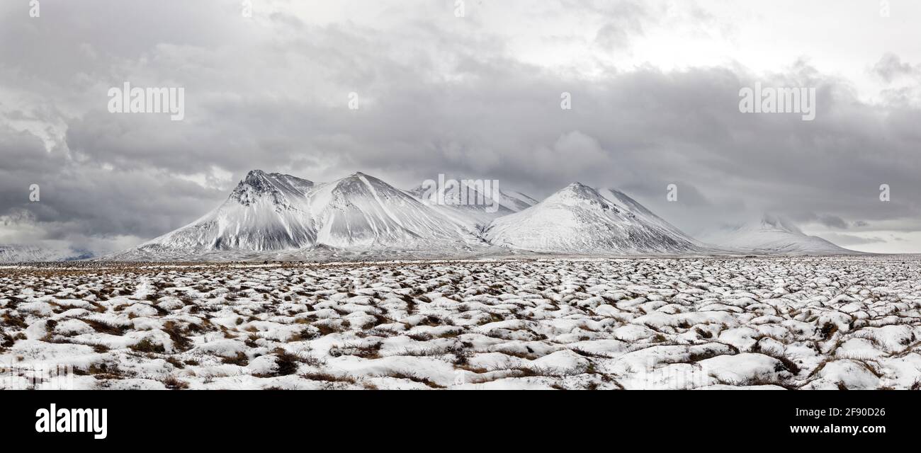 Karge Landschaft mit schneebedeckten Hügeln, Island Stockfoto
