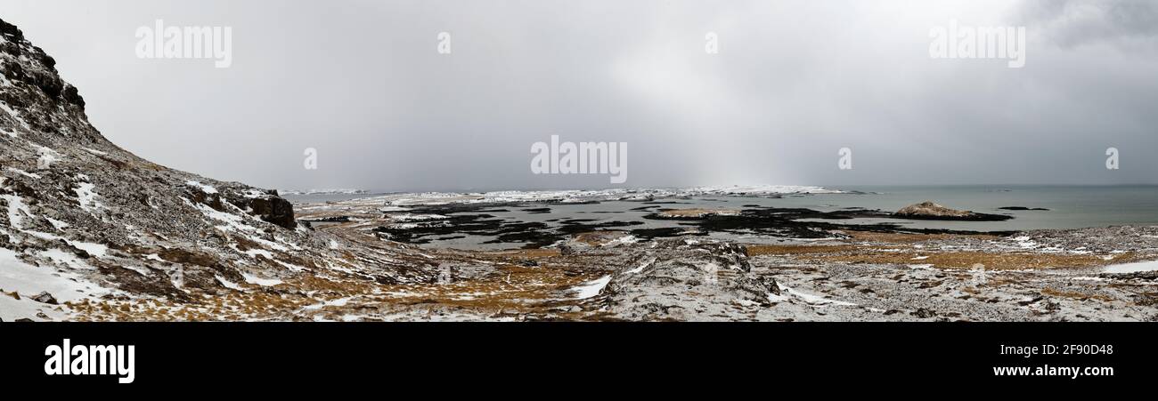 Karge Landschaft mit schneebedeckten Hügeln, Island Stockfoto