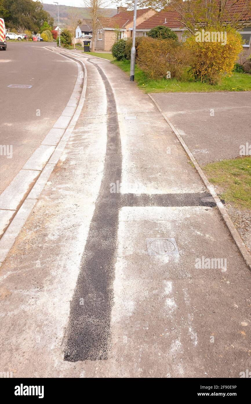 April 2021 - Reparaturen an Bürgersteig in einem Wohngebiet für die Installation von Kabel-Datennetzwerk. Stockfoto