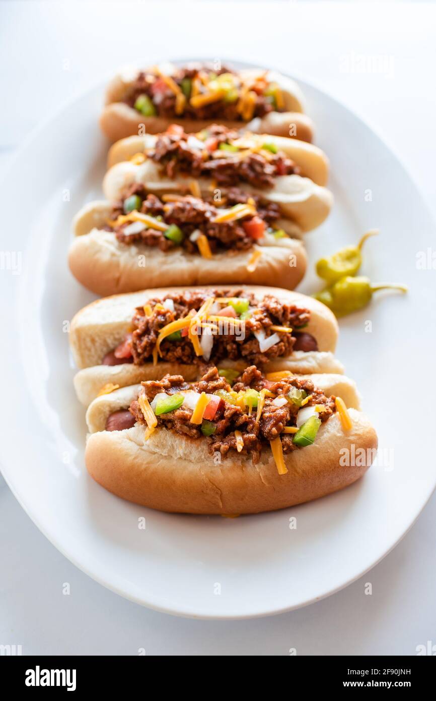 Nahaufnahme eines Tellers mit Chili-Hunden auf einer Theke aus weißem Marmor. Stockfoto