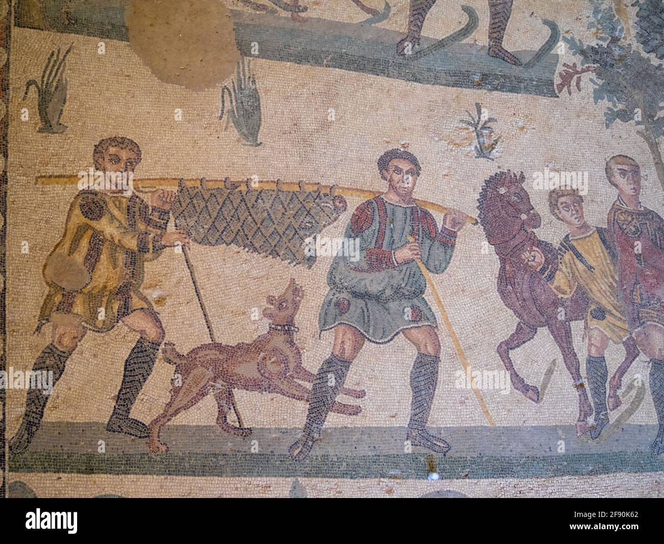 Zwei Mann, der ein Wildschwein in einem Netz trägt, Mosaikdetails aus dem Raum der kleinen Jagd, Villa Romana del Casale Stockfoto