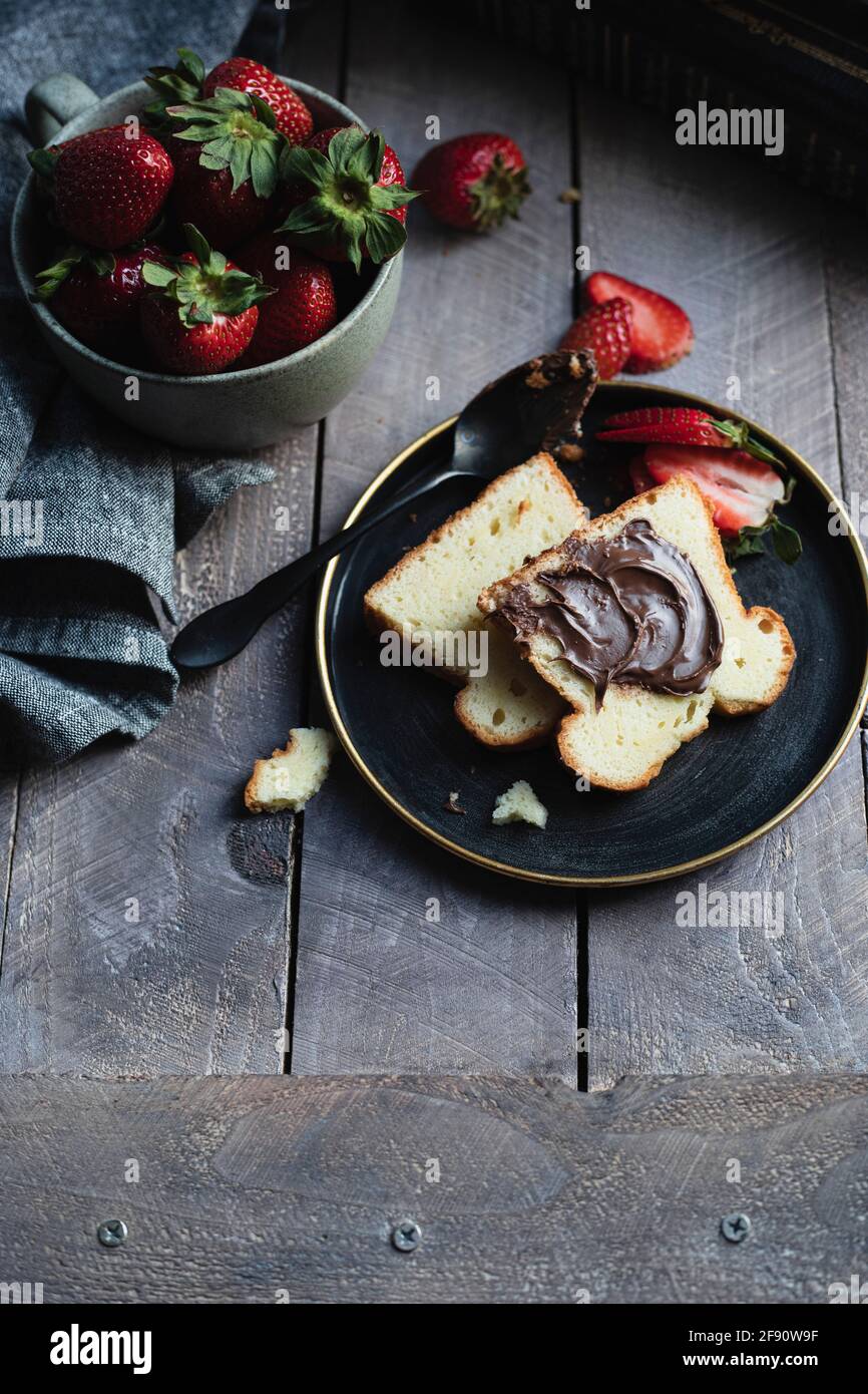 Frühstücksteller mit Biskuitkuchen und Erdbeeren Stockfoto