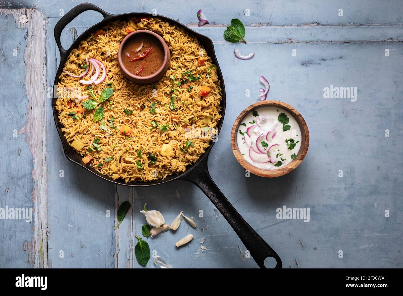 Pflanzliche Biryani in einer gusseisernen Pfanne, gebraten mit Raita Und Salan Stockfoto