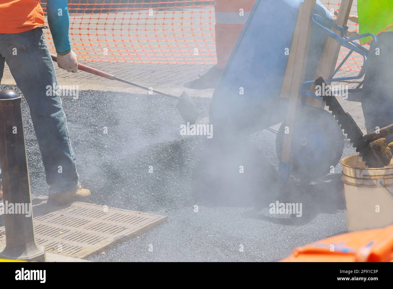 Straßenarbeiter reparieren Asphalt, der neue Straßenoberfläche beim Verlegen bedeckt Asphalt Stockfoto