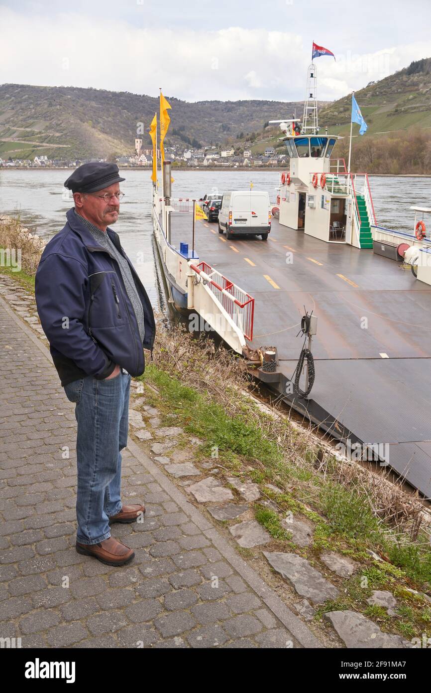 Niederheimbach, Deutschland. April 2021. Fährmann Michael Schnaas steht vor seiner Rheinfähre, die Niederheimbach in Rheinland-Pfalz mit Lorch in Hessen verbindet. Einige Rheinfähren transportieren während der Sperrung manchmal weniger als fünf Autos. Das lohnt sich kaum. Corona-Subventionen sollten den oft traditionellen Fähren helfen. (To dpa 'weniger Pendler und Touristen - Fähren leiden weiterhin unter Corona') Quelle: Thomas Frey/dpa/Alamy Live News Stockfoto