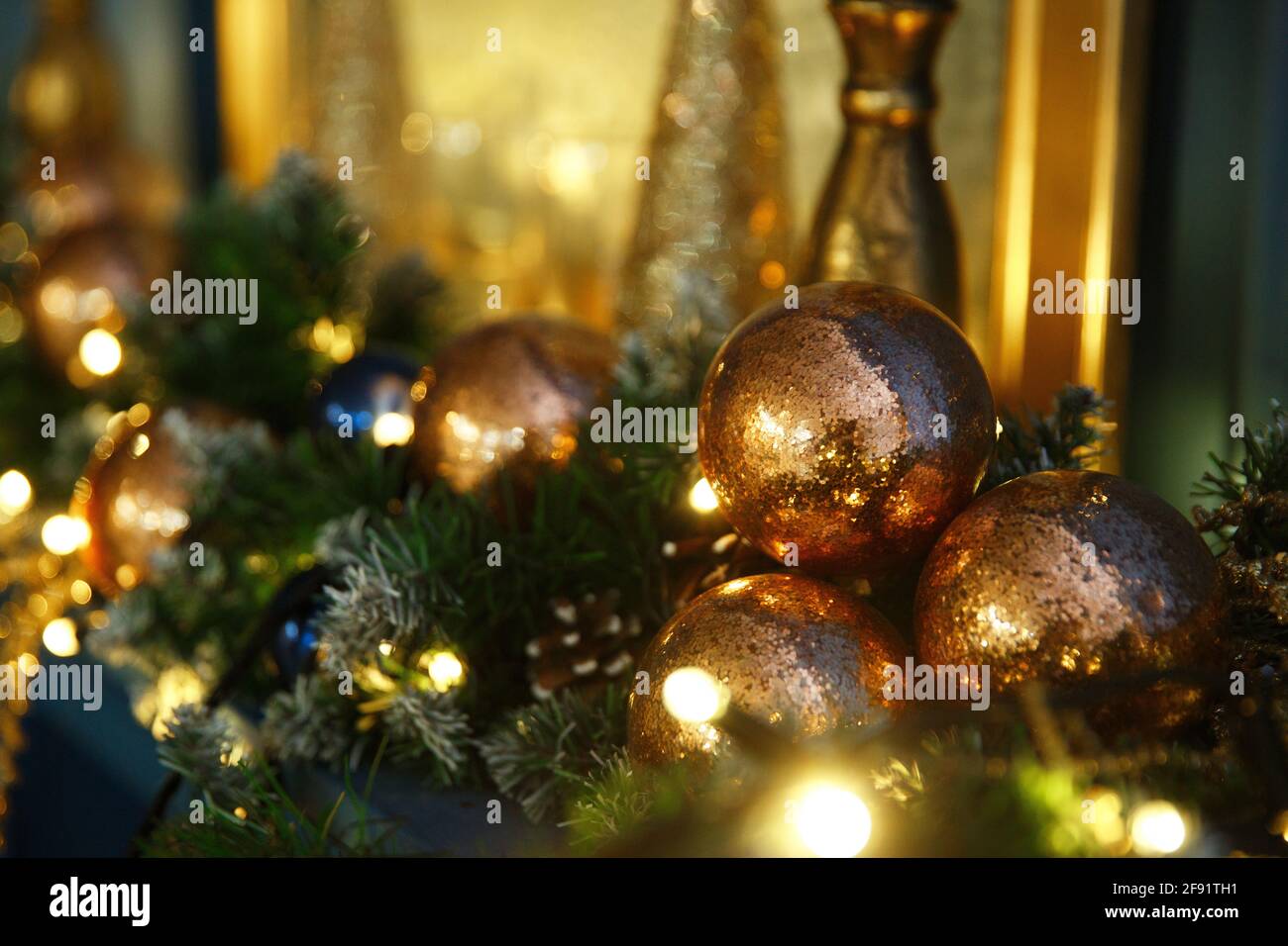 Helle Weihnachtslichter, Kugeln und Spielzeuge des neuen Jahres hängen am Baum und schimmern abends in verschiedenen Farben Stockfoto
