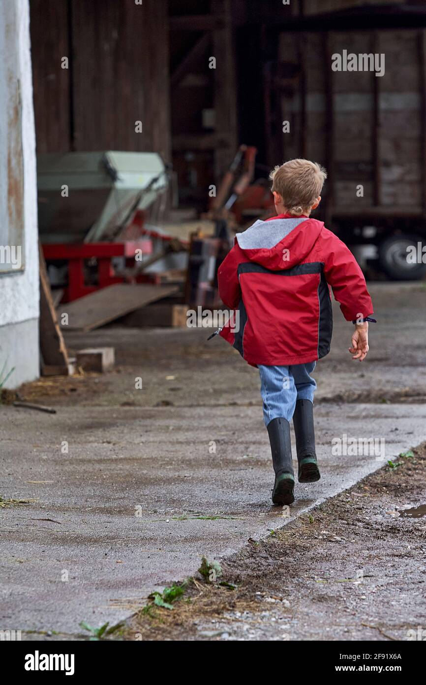 Junge, der auf dem Bauernhof wegläuft Stockfoto